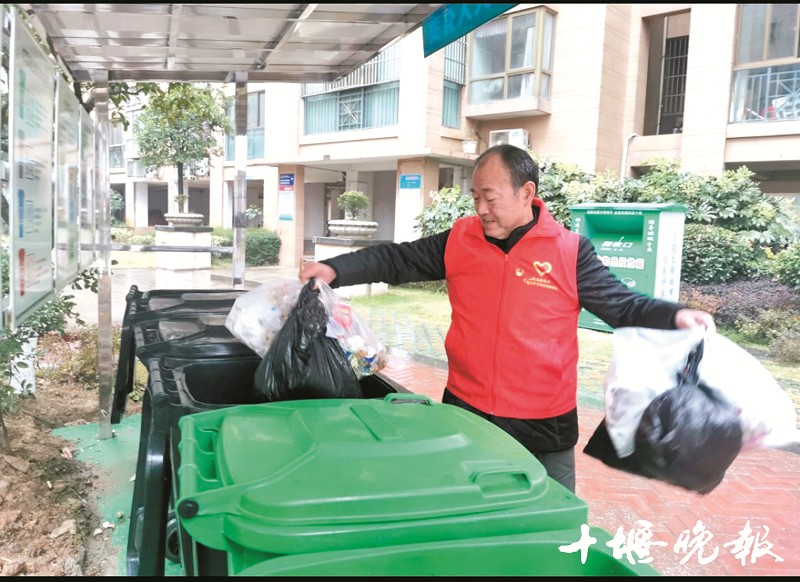 范祥先将堆积的垃圾丢进垃圾桶.